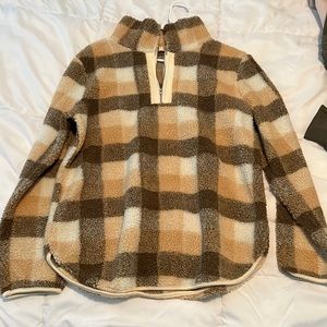 Large, fleece, orange and brown checkered pullover with front pocket.